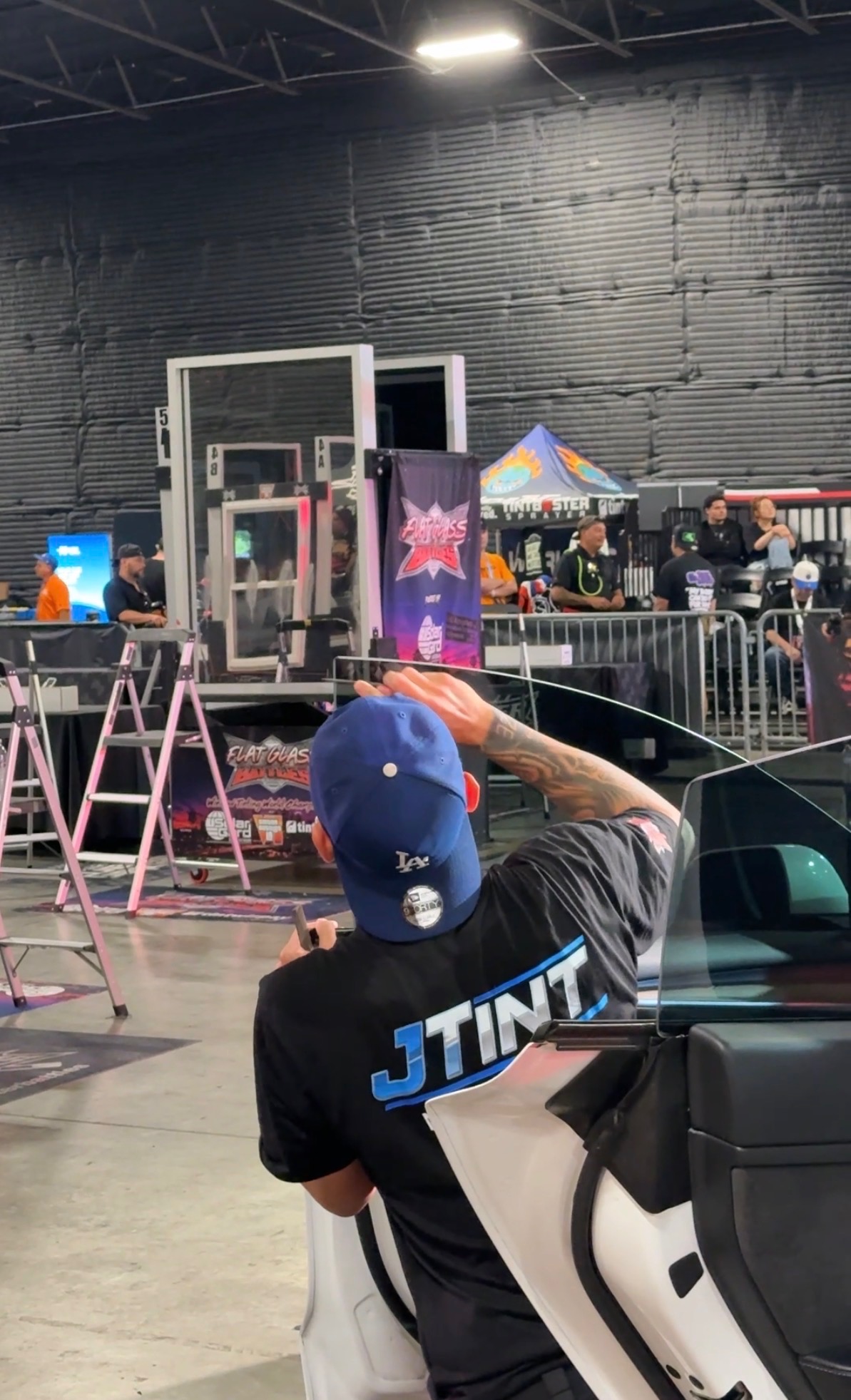 JT of JTINT installing tint on a door glass during head-to-head competition at Tinter Battles