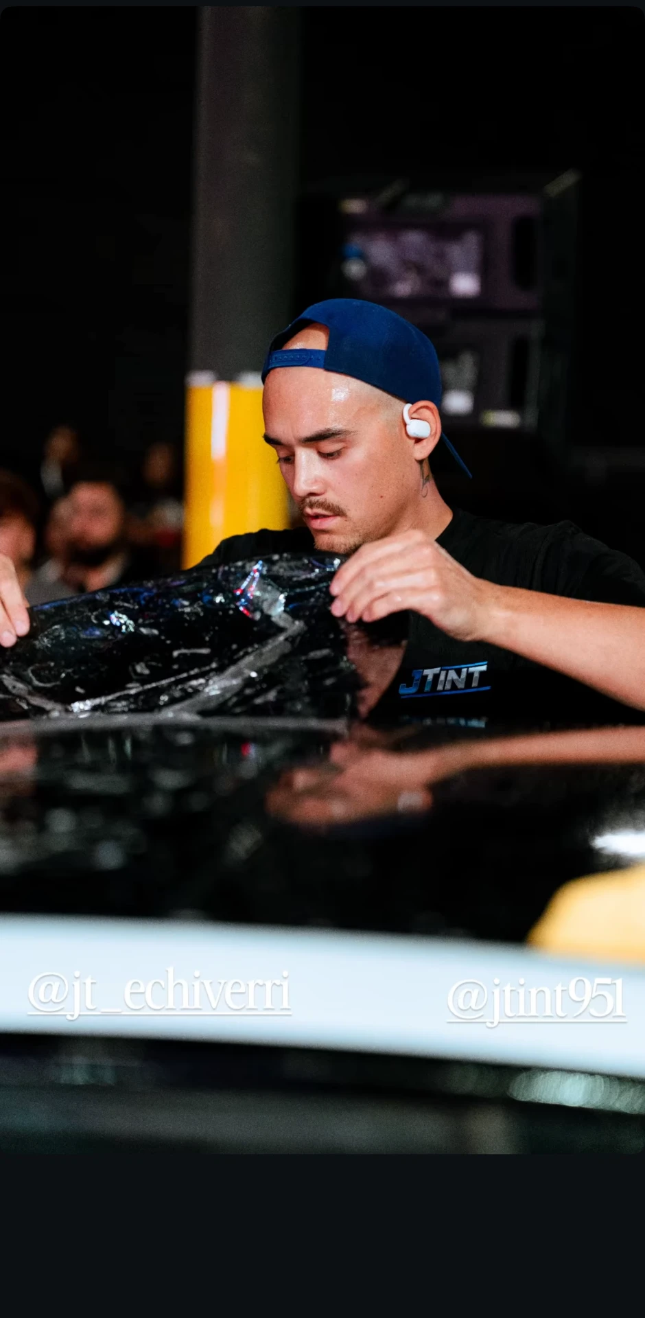 Close-up of JT laying competition-grade window film — the same Top 8 precision used on every JTINT vehicle